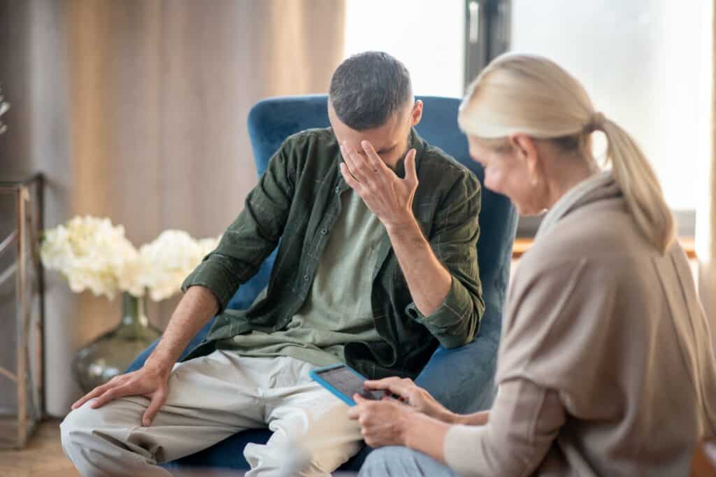 blonde haired psychoanalyst helping a man with depression