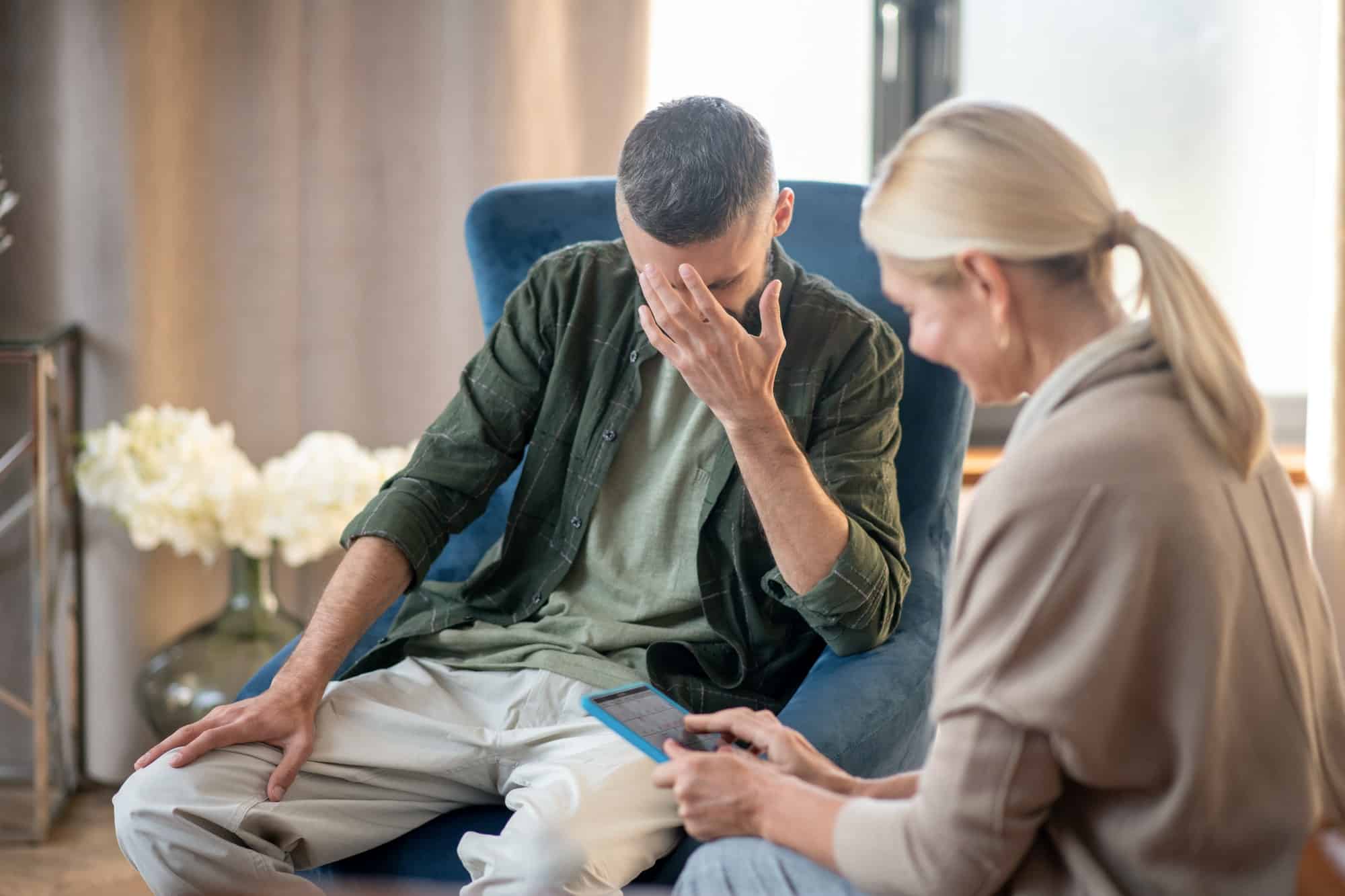 blonde haired psychoanalyst helping a man with depression